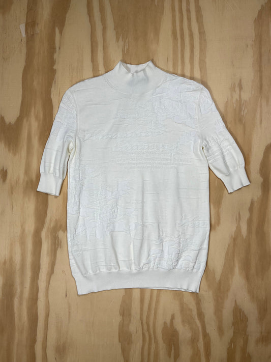 Front view of Kwaidan Editions white jacquard knit turtleneck with tonal logo and elbow-length sleeves.