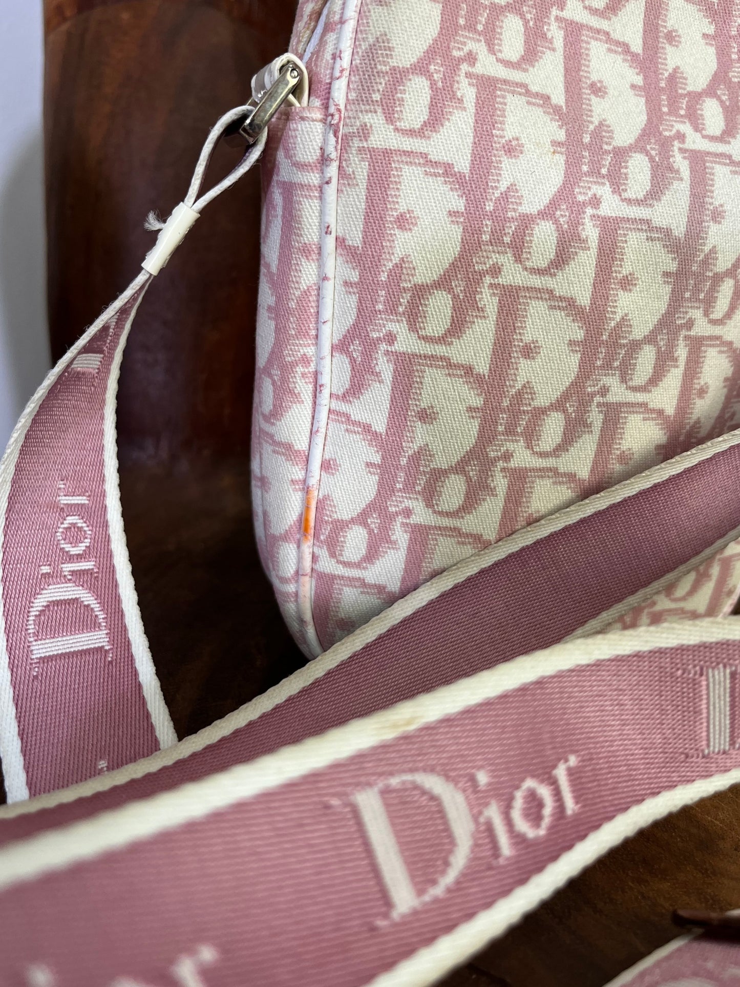 Side view of Dior pink Girly era crossbody bag with appliqué flowers and rhinestone trim.
