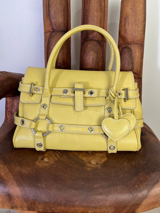 Vintage Luella Gisele bag in yellow grained leather with silver hardware, buckle details, and signature heart charm, iconic early 2000s It-bag.