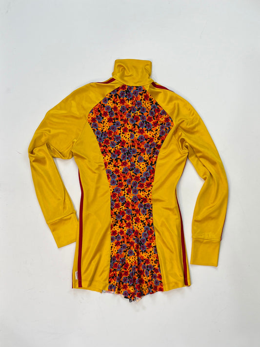 Marni yellow zip-up track jacket with multicolor floral panel, red sleeve stripes, high collar, and zippered pockets.