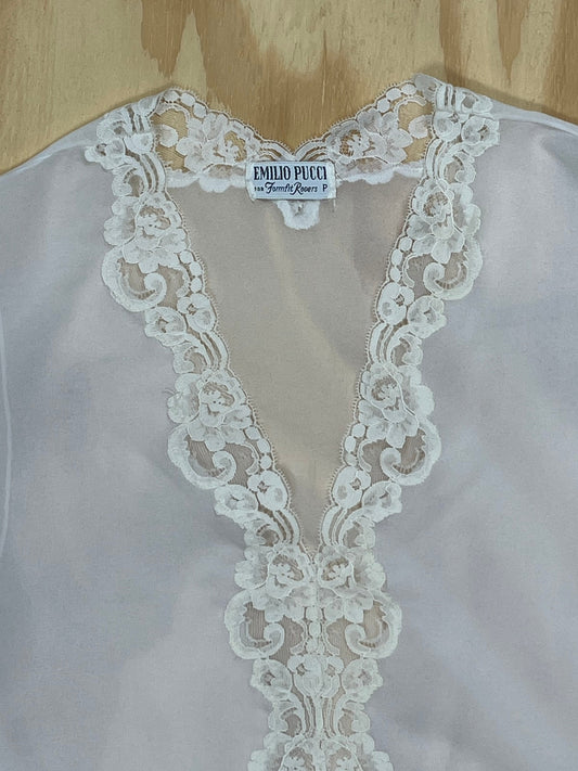 Close-up of Emilio Pucci for Fornell Rogers label on white lace blouse.