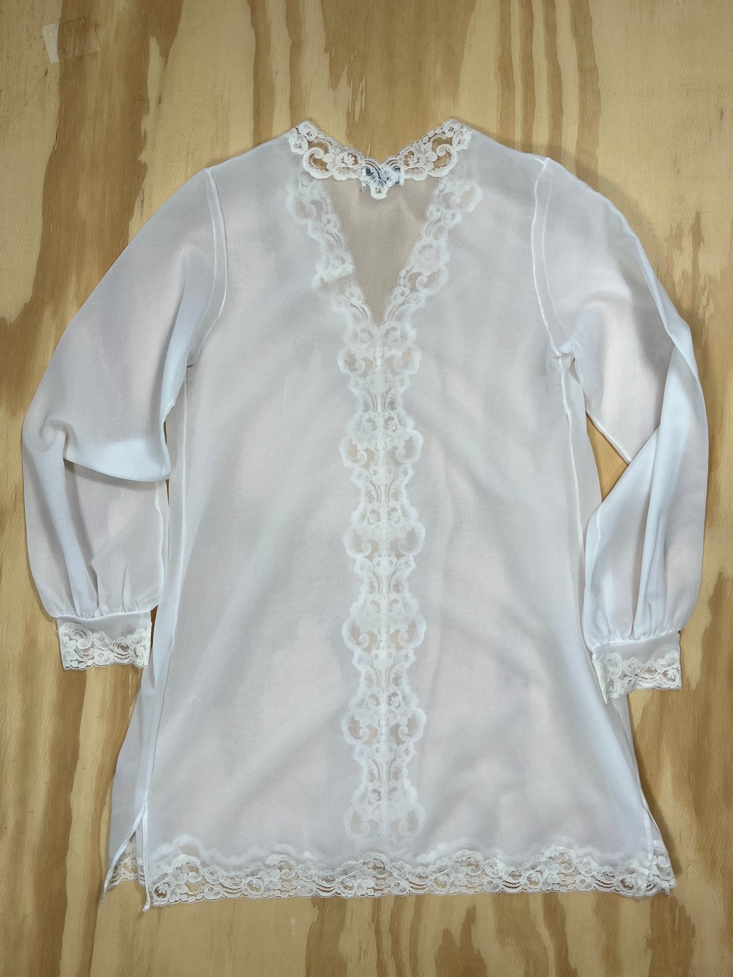 Back view of Emilio Pucci sheer tunic blouse with lace cuffs and hem.