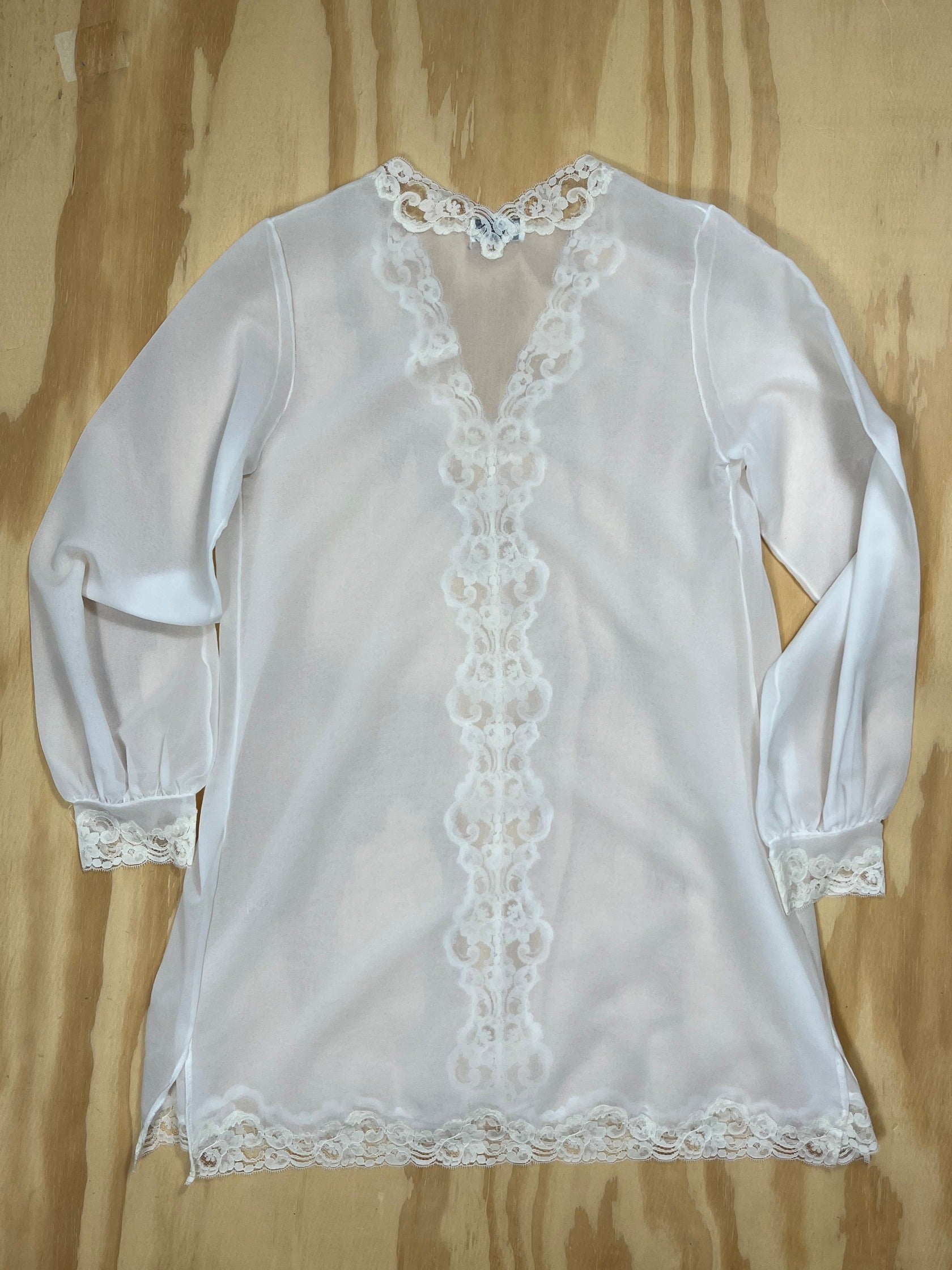 Back view of Emilio Pucci sheer tunic blouse with lace cuffs and hem.