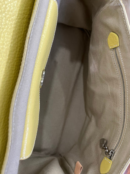 inside of Vintage Luella Gisele bag in yellow grained leather with silver hardware, buckle details, and signature heart charm, iconic early 2000s It-bag.