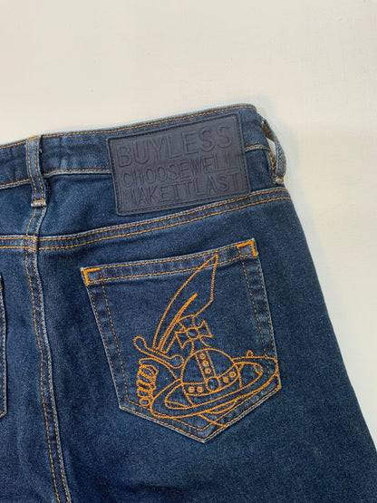 back pocket Vivienne Westwood dark blue skinny jeans with gold Orb embroidery on back pocket and black “Buy Less, Choose Well, Make It Last” patch at waistband. 