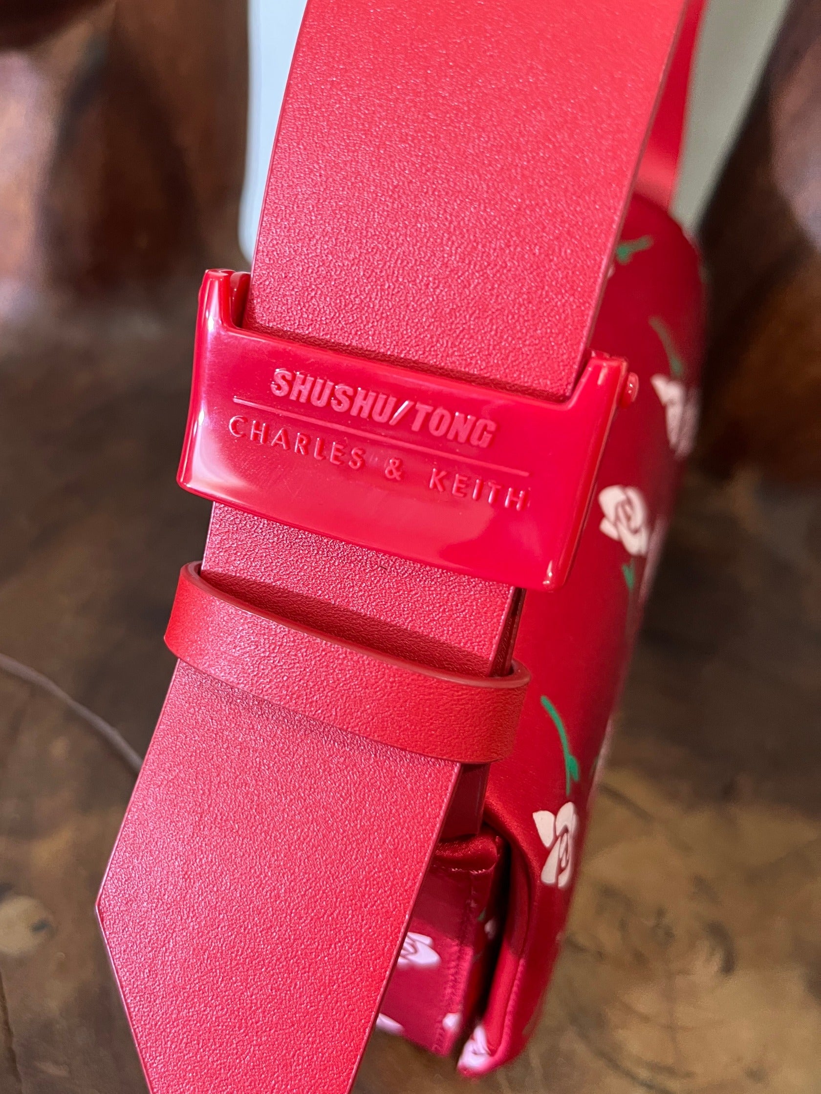 Red belt with 'Shushu/Tong' branding on a blurred background
