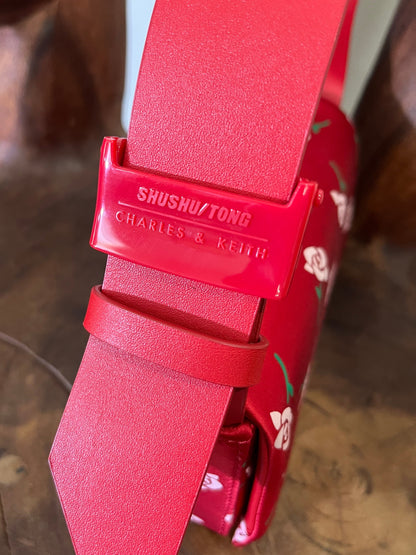 Red belt with 'Shushu/Tong' branding on a blurred background