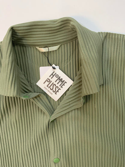 Issey Miyake Homme Plissé black pleated hoodie with drawstring hood, snap-button neckline, and kangaroo pocket.