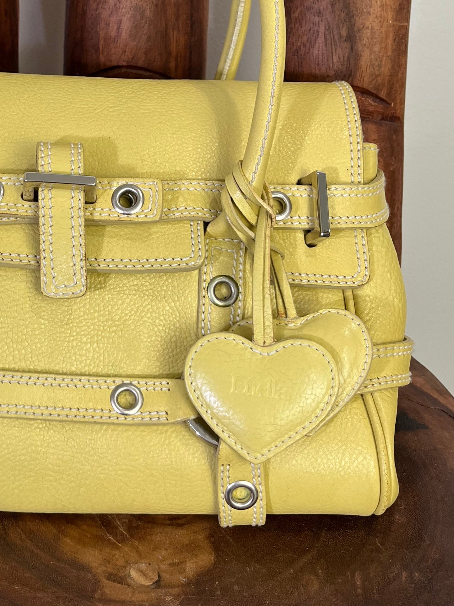 Vintage Luella Gisele bag in yellow grained leather with silver hardware, buckle details, and signature heart charm, iconic early 2000s It-bag.