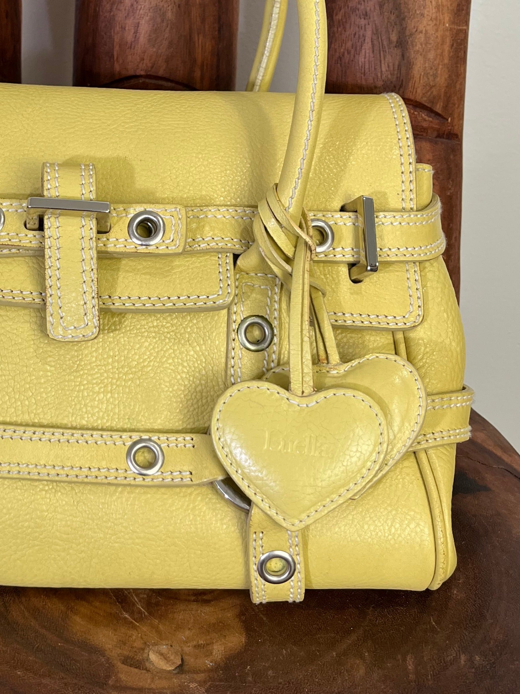Vintage Luella Gisele bag in yellow grained leather with silver hardware, buckle details, and signature heart charm, iconic early 2000s It-bag.