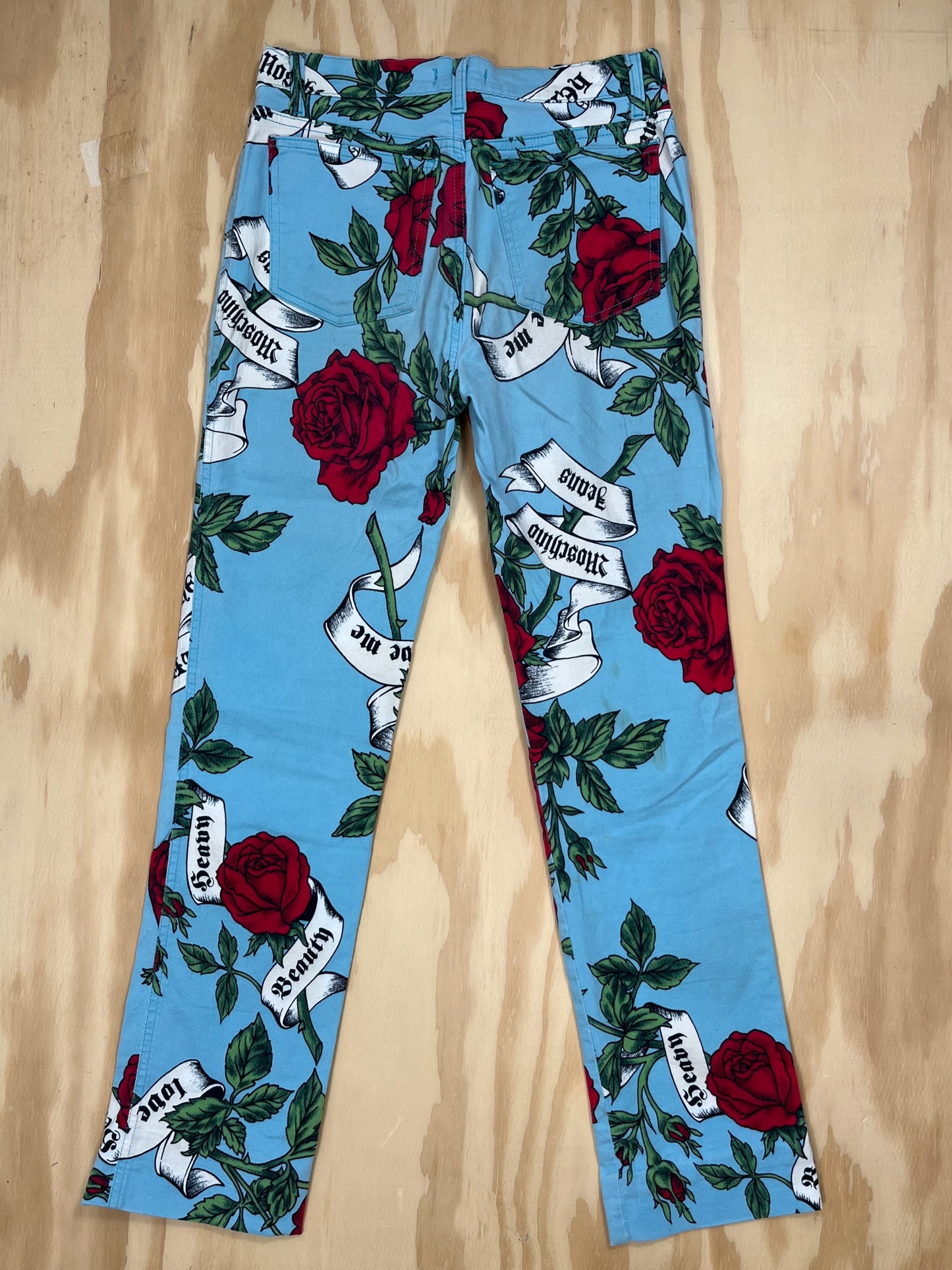 Back view of Moschino Jeans trousers with all-over rose and slogan print design.