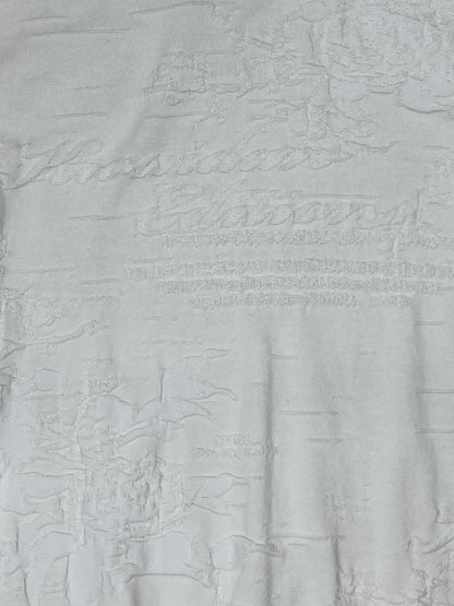 Close-up of textured jacquard pattern with tonal logo on Kwaidan Editions knit top.