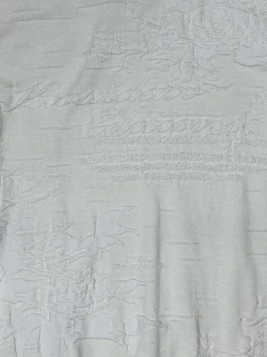 Close-up of textured jacquard pattern with tonal logo on Kwaidan Editions knit top.