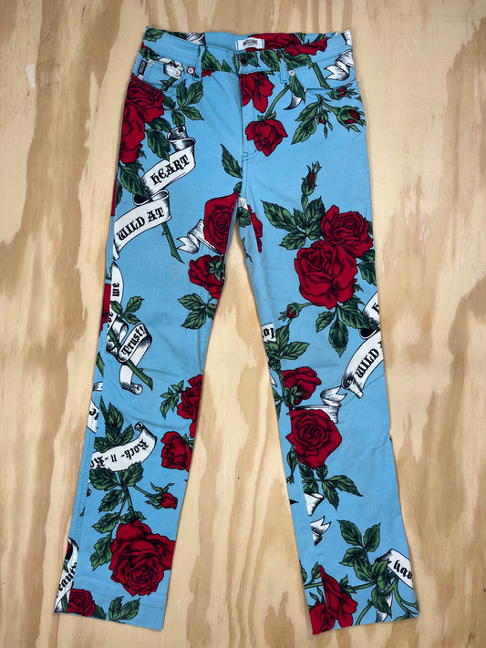 Front view of vintage Moschino Jeans blue trousers with red rose and slogan print.