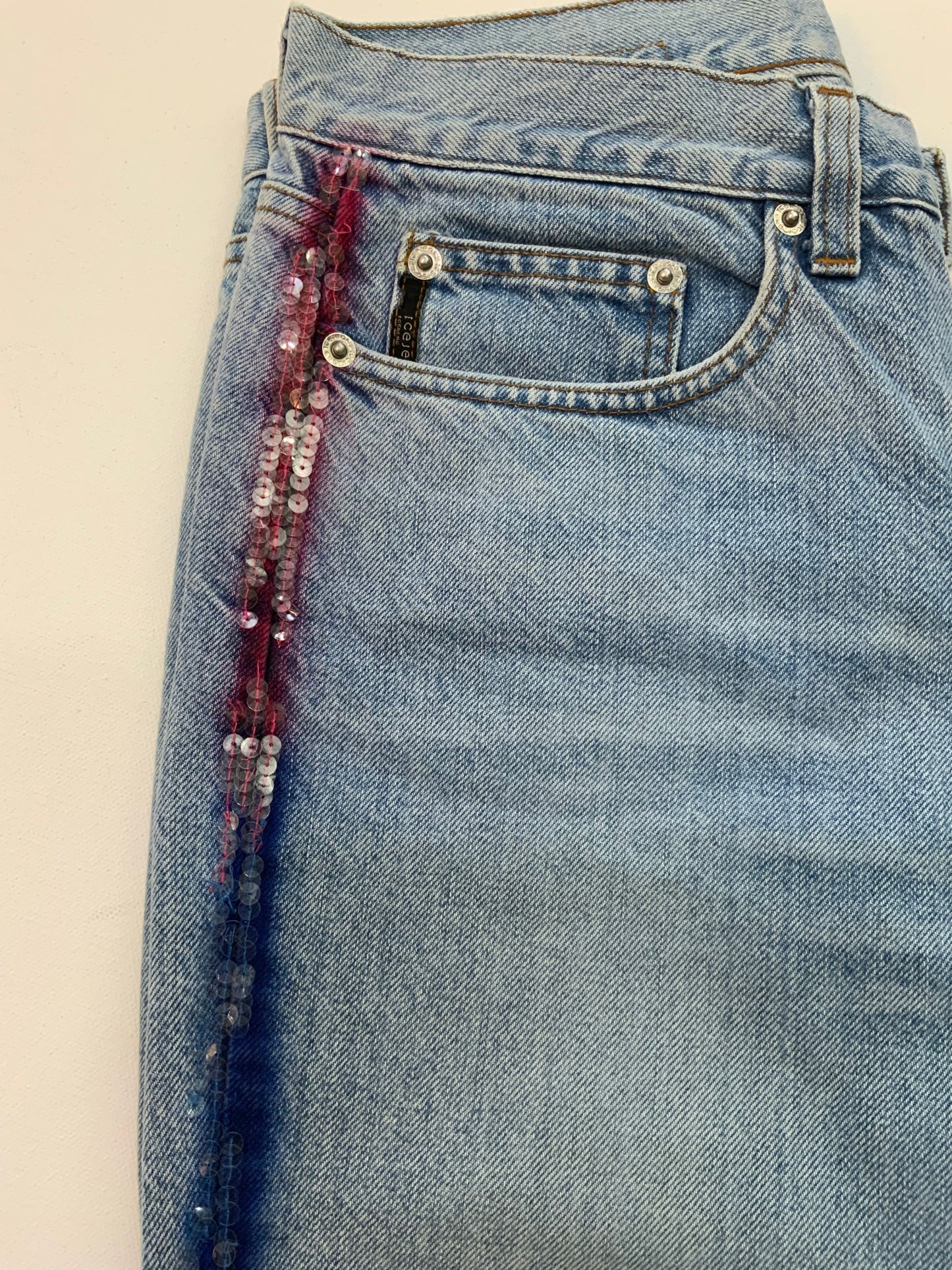 Vintage Iceberg denim jeans in light blue wash with rainbow sequin side stripes and Ice Jeans Iceberg back patch.